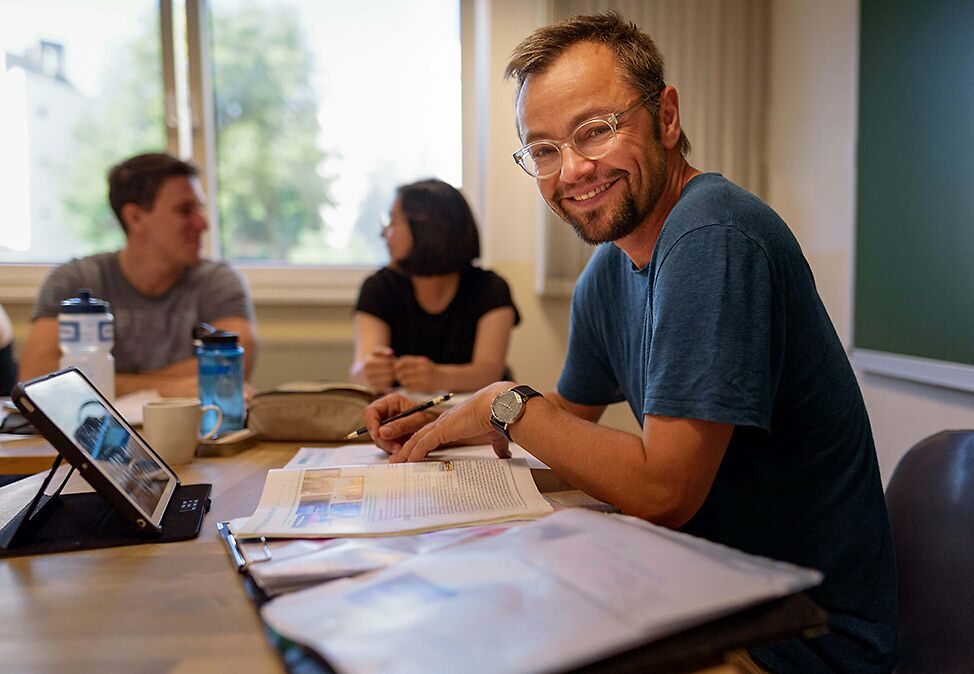 Ein Lehrer von DIE NEUE SCHULE Sprachschule Berlin in einem Deutschkurs mit Teilnehmern.